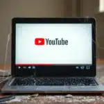 Abandoned laptop with dusty YouTube screen, showing how inconsistency ruins plans by losing trust and followers.