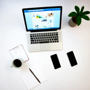 Workspace with laptop open to Facebook dashboard, coffee mug and notepad nearby