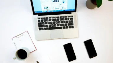 Workspace with laptop open to Facebook dashboard, coffee mug and notepad nearby