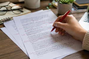 Printed draft being edited down into simpler, clearer writing for better readability.
